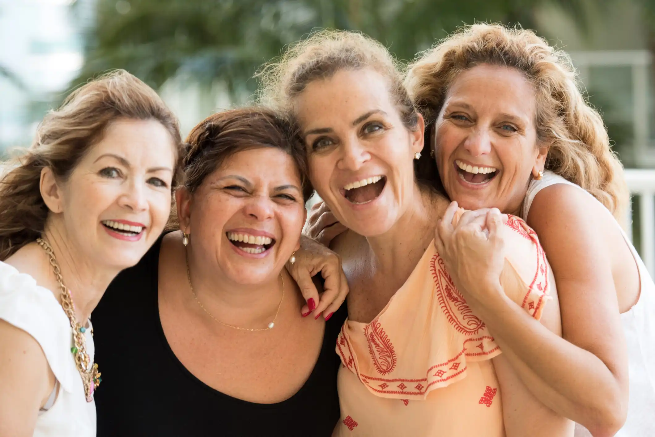Vier Frauen lachen ausgelassen zusammen